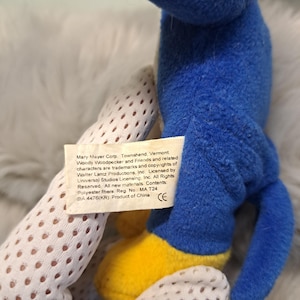 May include: A blue plush toy with yellow feet and a white fabric tag featuring the text: Mary Mayer Corp. Townshend, Vermont. Woody Woodpecker and Friends and related characters are trademarks and copyrights of Walter Lantz Productions, Inc.