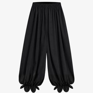 May include: Solid black trousers featuring a high-waisted elastic waistband, a loose and voluminous leg silhouette, and gathered cuffs at the ankles that are finished with a distinct scalloped, petal-like edge detail along the bottom hem.