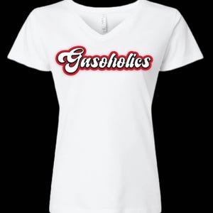 May include: White V-neck t-shirt with the word "Gasoholics" in a red and white outlined script. The shirt is a casual style, suitable for everyday wear.