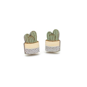 May include: A pair of wooden earrings featuring a green cactus plant in a white and cream pot.