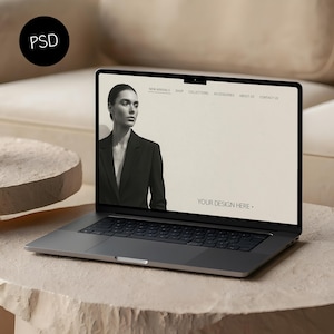 May include: A silver laptop displaying a website mockup with a woman in a black blazer. The screen shows the text "NEW ARRIVALS SHOP COLLECTIONS ACCESSORIES ABOUT US CONTACT US" and "YOUR DESIGN HERE."