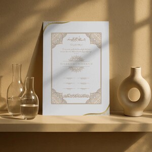 Op de afbeelding: Een ingelijst wit certificaat met gouden sierlijke randen en tekst. Het certificaat wordt weergegeven op een plank met twee heldere glazen flessen en een beige vaas. De achtergrond is een neutraal beige.