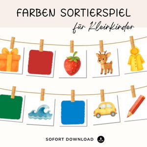 Könnte beinhalten: Eine Reihe von Karten mit Illustrationen, die mit Holzklammern an einer Schnur befestigt sind. Die Karten zeigen farbenfrohe Bilder wie eine Geschenkbox, eine Erdbeere, ein Reh und ein gelbes Auto. Der Text lautet "FARBEN SORTIERSPIEL für Kleinkinder".