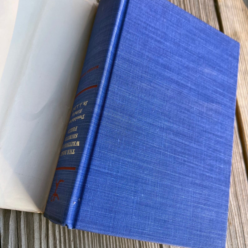 Puede incluir: Un libro de tapa dura azul con el t&iacute;tulo "The Time of the Assassins" de William Shirer y el texto "A History of the French Revolution" impreso en el lomo.