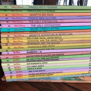 Może przedstawiać: Stos 20 kolorowych książek w miękkiej oprawie z logo Walta Disneya i tytułami takimi jak "Przyrzeczenie Pinokia", "Wielki wyścig Goofy'ego", "Nowe ubrania Kubusia Puchatka", "Brzydkie siostry", "Myszka Miki znajduje kociaka", "Przygoda Wendy w Nibylandii", "Witaj z powrotem, Śnieżka", "Sknerus McKwacz i magiczna ryba", "Ferdynand i łobuzy", "Dobre serce Hiawatha", "Mały wilk ratuje dzień", "Liczby od 1 do 10", "Przygody w kolorach i kształtach", "Duże i małe, takie samo i inne", "Ptaki i drzewa, kwiaty i pszczoły", "Cudowna Ziemia", "To mały świat", "Ludzie w pracy", "Jazda, pływanie i latanie", "Rymowanki i zagadki, wygłupy i śmiech", "Przewodnik po zabawie i nauce", "Gigantyczny plan Minnie", oraz "Jak Kubuś Puchatek zdobył swój miód".