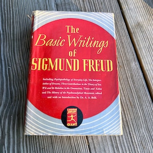Puede incluir: Un libro de tapa dura rojo con el t&iacute;tulo "The Basic Writings of Sigmund Freud" en letras blancas. El libro forma parte de la serie Modern Library Giant.