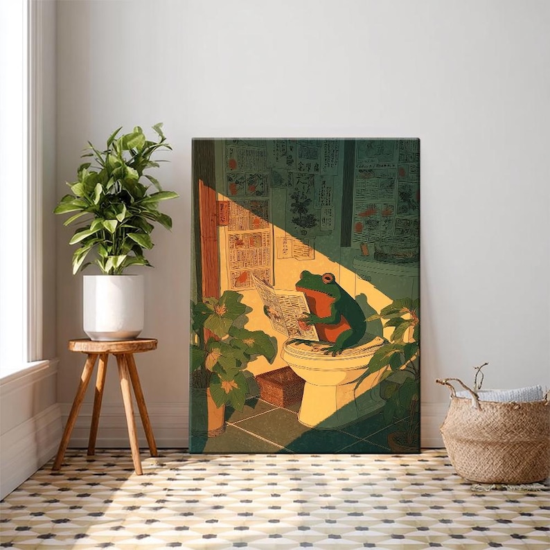 Puede incluir: Una impresi&oacute;n art&iacute;stica enmarcada representa una rana verde leyendo un peri&oacute;dico en un inodoro. La obra de arte tiene una est&eacute;tica vintage, con una paleta de colores verde, naranja y amarillo. La escena est&aacute; ambientada en un ba&ntilde;o con plantas y luz solar.
