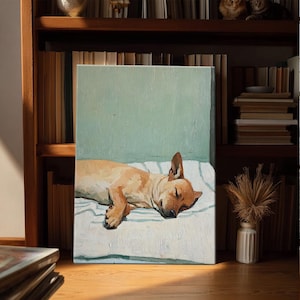 Può includere: Dipinto a olio raffigurante un cane marrone chiaro che dorme pacificamente su una superficie a righe bianche e blu. Lo sfondo è verde chiaro. L'opera d'arte è esposta su una mensola di legno con libri.