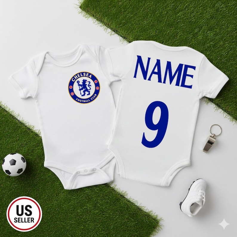 May include: Two white baby onesies with blue text and graphics. One has the Chelsea Football Club logo, the other has "NAME" and the number "9". A soccer ball, whistle, and baby shoe are also present.