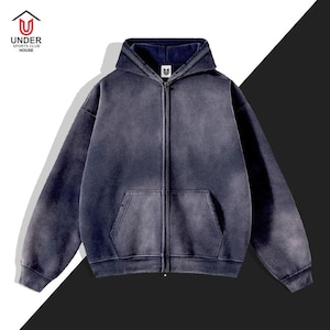 May include: A dark blue zip-up hoodie with a faded, vintage look. The hoodie features a drawstring hood, a front pocket, and the "UNDER SPORTS CLUB HOUSE" logo in white. The jacket has a full-length zipper and ribbed cuffs.
