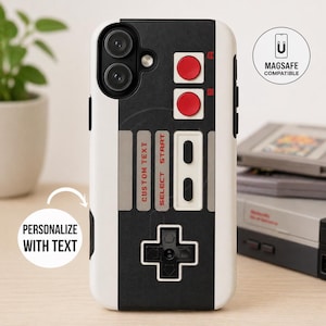 May include: A white and black phone case with a retro video game controller design. The case features red buttons, a directional pad, and the words "CUSTOM TEXT" and "SELECT START". The case is MagSafe compatible and can be personalized.