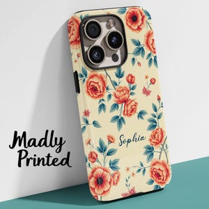 May include: A phone case with a floral design featuring orange roses and blue leaves on a cream background. The name "Sophia" is written in cursive. The words "Madly Printed" are in black script on the left.