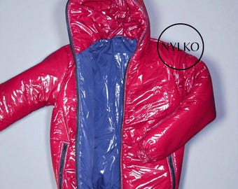 May include: A shiny red hooded jacket with a blue interior. The jacket has a zipper closure and two side pockets. The material has a glossy, reflective finish. The jacket is designed for cold weather.