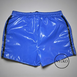 Può includere: Pantaloncini blu brillante con finitura lucida e bagnata. I pantaloncini hanno un elastico in vita con coulisse e strisce nere sui lati. Realizzati in un materiale liscio, possibilmente sintetico.