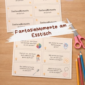 May include: A set of printed cards with the text "FantasieMomente am Esstisch" in German, along with prompts and illustrations. The cards are on a wooden surface, with colored pencils and scissors nearby.