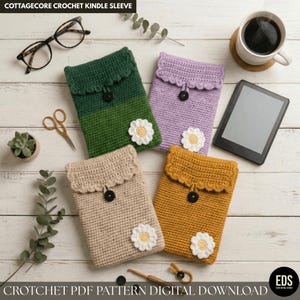 May include: Four handmade crochet Kindle sleeves in green, purple, tan, and mustard yellow, each with a scalloped top, a black button closure, and a white daisy accent. The text "COTTAGECORE CROCHET KINDLE SLEEVE" is at the top.