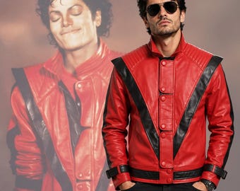 May include: A red and black leather jacket featuring a high collar, quilted shoulder panels, and a front button closure. The design includes black V-shaped accents across the chest and black trim on the sleeves and cuffs, worn with black trousers.