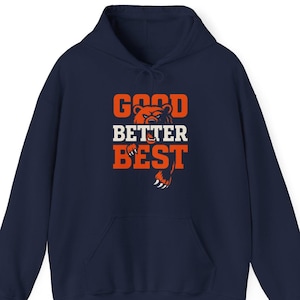 May include: Navy blue hooded sweatshirt with the words "GOOD BETTER BEST" in orange and white block letters. A bear graphic is incorporated into the design. The sweatshirt has a front pocket and a drawstring hood.