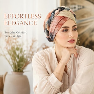 May include: A head wrap featuring a braided design with a tie-dye pattern in shades of rust, beige, and dark blue. The text on the image reads: EFFORTLESS ELEGANCE. Everyday Comfort, Timeless Style. The head wrap is worn with gold hoop earrings.