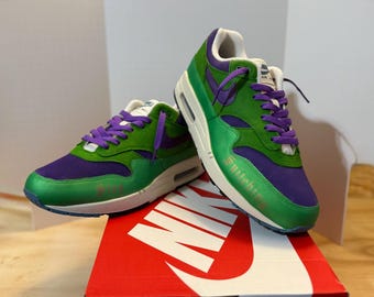 Sneakers Nike Air Max 1 personalizzate: scarpe streetwear dipinte a mano con design "Stop Snitching" verde e viola