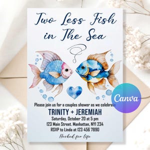 Pode incluir: Cartão de convite com ilustrações em aquarela de dois peixes voltados um para o outro, com o texto "Two Less Fish in The Sea". O cartão inclui detalhes do evento para o chá de casal de Trinity e Jeremiah, com corações e bolhas.