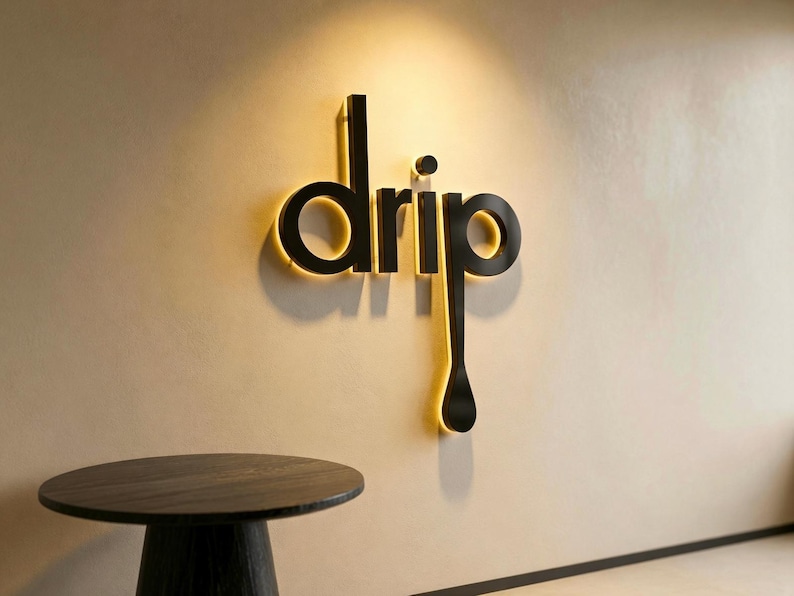 May include: A three-dimensional wall sign featuring the word drip in black lettering. The letter p extends downward into a long, teardrop-shaped tail. The sign is backlit with a warm glow, casting a soft shadow against the light-colored wall.