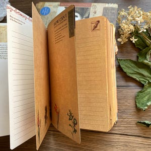 May include: Open vintage journal with lined pages and decorative floral illustrations. The journal has a brown cover and pages, with text that reads "How Can I Let You Walk Away?" and "Been saved for the son of the famous Joshua."