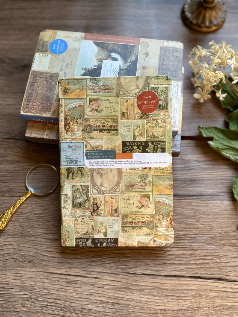 May include: A stack of vintage-style boxes with a collage of old advertisements and labels. The top box has a blue sticker. The front box features the text "Kavin Sunlight soap" and "British Empire". A magnifying glass rests nearby.
