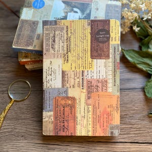 May include: A stack of vintage-style notebooks with a collage of old tickets and ephemera. The top notebook features a label that reads "Kavin Sunlight soap". The color palette includes browns, tans, and faded blues, creating a nostalgic aesthetic.