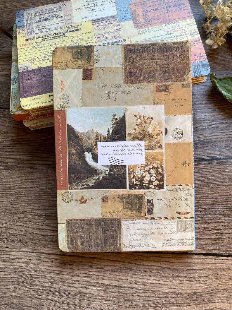May include: A stack of vintage-style journals with covers adorned with postage stamps, old letters, and landscape imagery. The journals have a rustic, antique aesthetic, with a color palette of beige, brown, and cream. The top journal has a yellow cover.