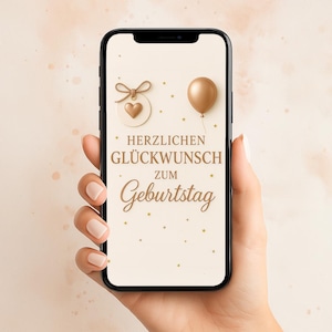 Könnte beinhalten: Ein Smartphone zeigt eine Geburtstagskarte auf Deutsch. Der Text lautet "Herzlichen Glückwunsch zum Geburtstag", mit einem goldenen Ballon und einem herzförmigen Anhänger. Das Telefon wird in einer Hand gehalten.