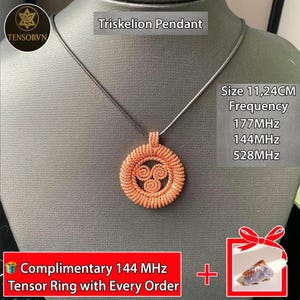 Puede incluir: Colgante Triskelion de color cobre sobre una cadena plateada. El colgante es circular, con un diseño en espiral y un tamaño de 11,24 cm. La imagen también incluye texto que indica frecuencias de 177MHz, 144MHz y 528MHz.