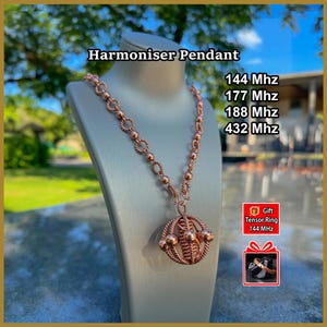 Puede incluir: Un collar con colgante Harmoniser de color cobre con un diseño de jaula esférica de alambre trenzado y pequeñas esferas. El texto dice Harmoniser Pendant, 144 Mhz, 177 Mhz, 188 Mhz, 432 Mhz y Gift Tensor Ring 144 Mhz con una imagen de un anillo.