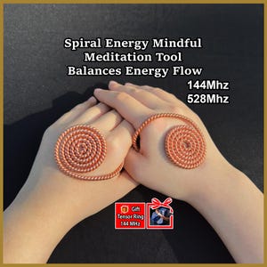 May include: Two copper-colored metal spiral coils, each featuring a twisted wire design. Text on the image reads: Spiral Energy Mindful Meditation Tool Balances Energy Flow, 144Mhz, 528Mhz, and Gift Tensor Ring 144 MHz with a small graphic.
