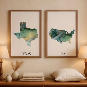 May include: Two framed wall art prints featuring the outlines of Texas and the USA. The maps are filled with a marbled teal, green, and gold alcohol ink pattern. The left print is labeled TEXAS and the right print is labeled USA with a small red heart.
