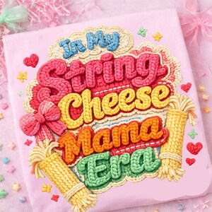 May include: A pink, square-shaped item with the text "In My String Cheese Mama Era" in a colorful, knitted design. The design includes a bow, hearts, stars, and two bundles of string cheese.