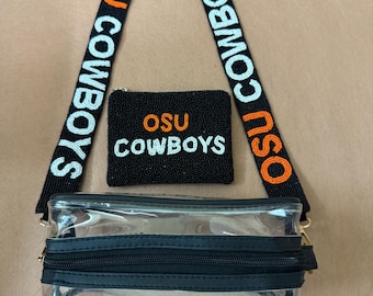 May include: A clear crossbody bag with a black zipper and strap. The strap is black with "OSU COWBOYS" in orange and white lettering. A small black beaded wallet with "OSU COWBOYS" in orange and white lettering is also included.