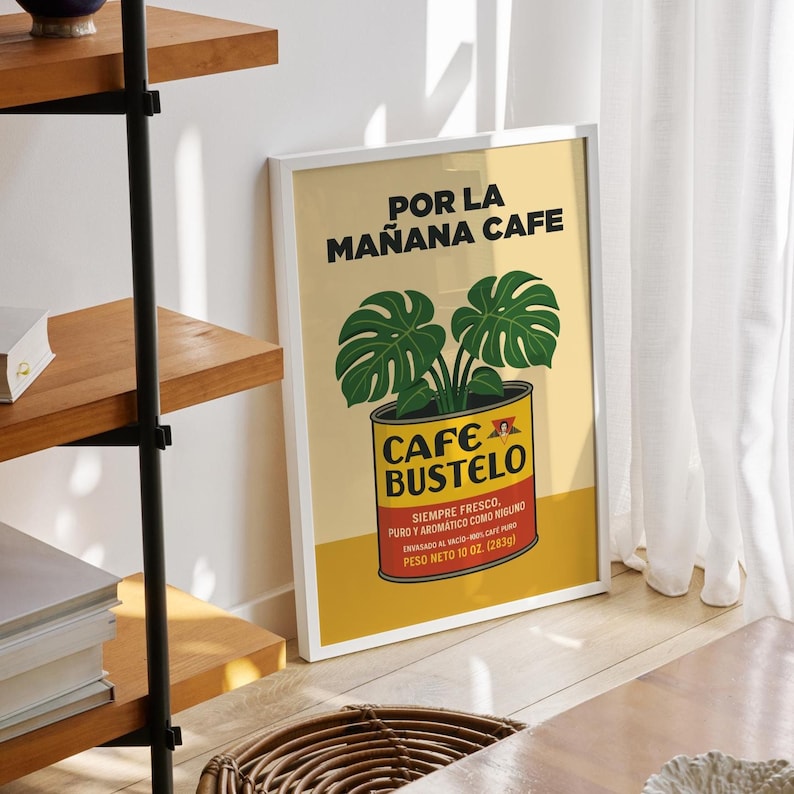 May include: A framed poster with a yellow background features the text "POR LA MA&Ntilde;ANA CAFE" and "CAFE BUSTELO". A green plant is in a coffee can. The bottom text reads "PESO NETO 10 OZ. (283g)".