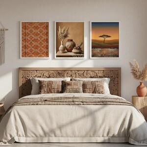 Three African-inspired art prints in gold frames above a boho bedroom headboard, featuring a warm earth-tone geometric textile, an elegant African queen portrait, and a golden savanna sunset landscape with tribal border details