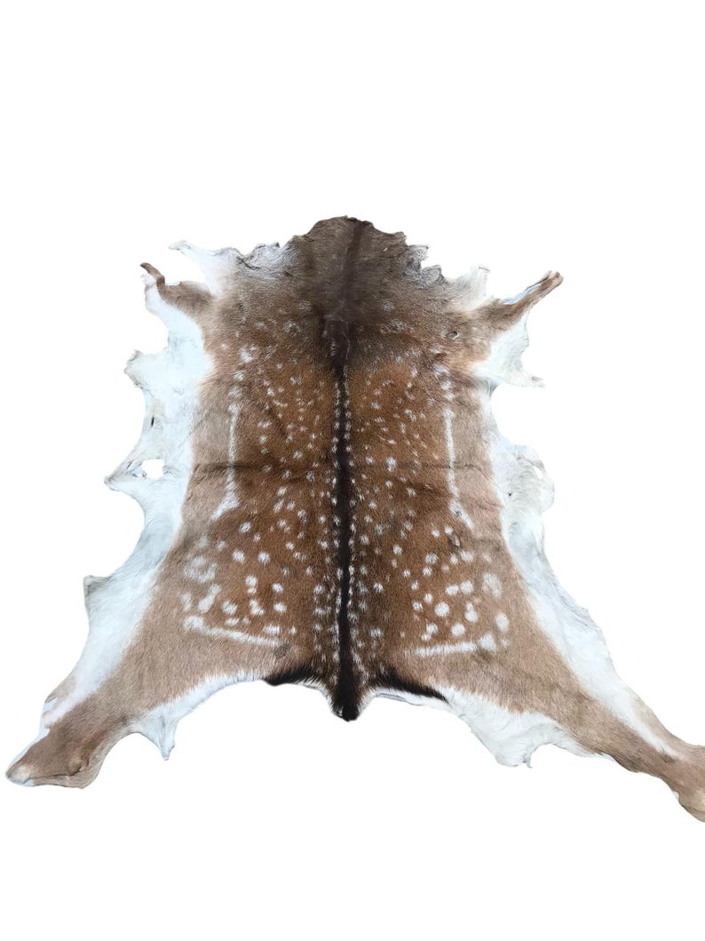 May include: A deer hide rug with a natural spotted pattern in shades of brown and white. The hide is spread out, showcasing its shape and texture. The rug is likely used as a decorative floor covering.