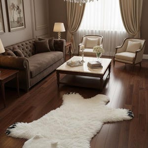 Pode incluir: Um tapete de pele sintética branca em forma de urso polar, com patas pretas e nariz preto. O tapete está sobre um chão de madeira escura numa sala de estar com um sofá e cadeiras castanhas.