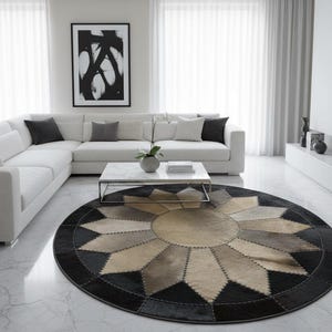 Op de afbeelding: Een moderne woonkamer met een witte hoekbank, een salontafel met marmeren blad en een rond tapijt met een geometrisch patroon in zwart, beige en grijstinten. Een abstract kunstwerk in een lijst hangt aan de muur.