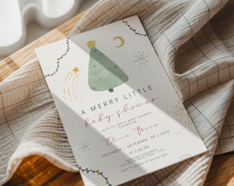 May include: A baby shower invitation featuring a Christmas tree design. The card says "A Merry Little Baby Shower" with event details. The design incorporates festive elements such as stars, a crescent moon, and fairy lights, perfect for a winter celebration.