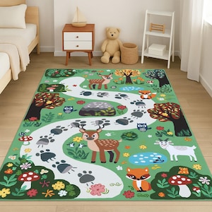 May include: A green area rug with a whimsical forest scene. The rug features a winding white path with animal footprints, deer, foxes, owls, and mushrooms. The rug is approximately 60 inches wide and 84 inches long.