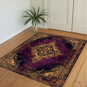 May include: A rectangular rug with a dark purple and gold ornate design. The rug features a central medallion and a detailed border. The color palette includes shades of purple, black, and gold, creating a luxurious feel. The rug is placed on a wooden floor.