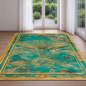 Könnte beinhalten: Ein rechteckiger, türkisfarbener Teppich mit einem goldenen Palmfächer-Design. Der Teppich hat einen goldenen Rand und ein zentrales fächerförmiges Design. Der Teppich liegt auf einem Holzboden vor einem Fenster.