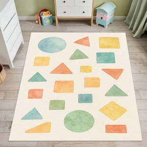 Puede incluir: Una alfombra rectangular crema con un diseño de acuarela de formas geométricas. Las formas incluyen círculos, triángulos, cuadrados y diamantes en tonos de azul, verde, naranja y amarillo. La alfombra es para una habitación infantil.