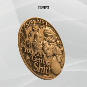 May include: A gold-colored, circular relief sculpture featuring Santa Claus giving the middle finger. The text on the sculpture reads "YOU AIN'T GETTING SHIT!" with snowflake and bell accents. The text "STLPROJECT" is in the upper left corner.