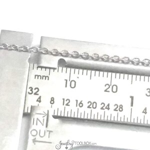 May include: A close-up of a silver chain measured with a ruler. The ruler shows measurements in millimeters from 32 to 30. The chain is 1 mm wide.