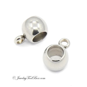 May include: Two silver-toned metal bead caps with a loop on top. The bead caps are round and have a hole in the center. They are used for jewelry making.